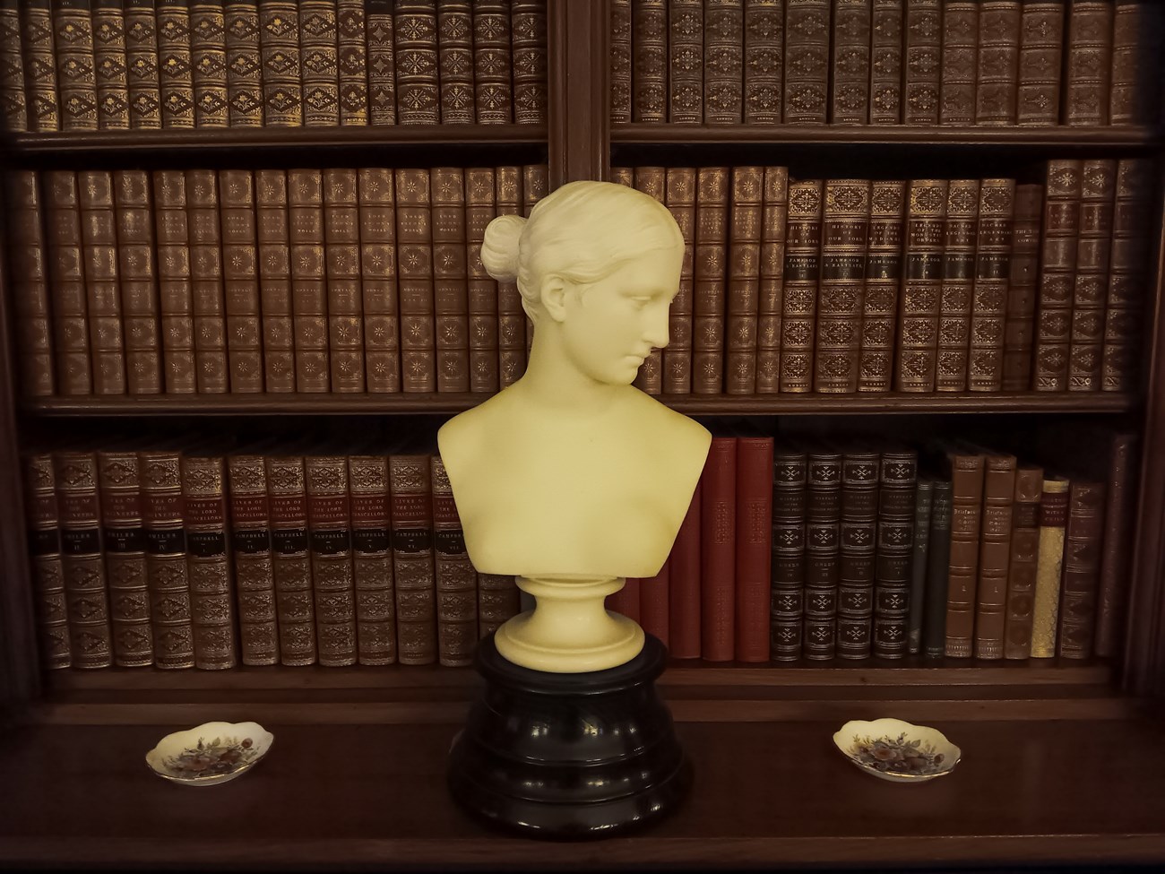 The Greek Slave in Marsh-Billings-Rockefeller Mansion Library bust of the sculpture "The Greek Slave" in front of a shelf of historic books