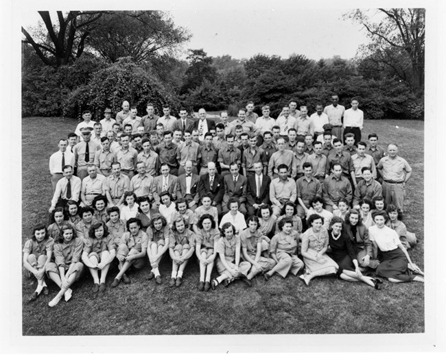Group of Employees from Bonebrake, Unit 3 and Runnymede, Unit 4 A group of more than 50 people. Women sit on the ground in the first 2 rows. Men are either seated or standing behind the women.
