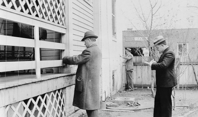 HABS documentation in 1934 Two men measure a building as another stands by taking notes.