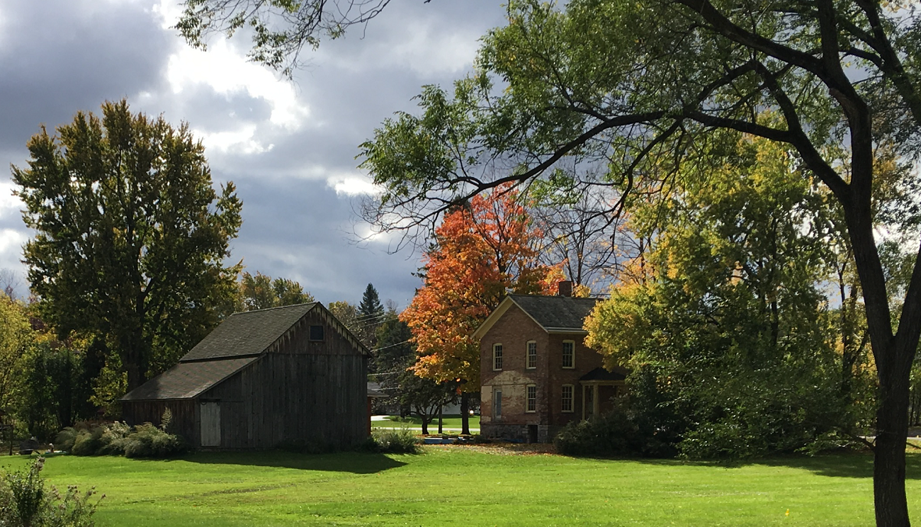 Historic farmhouse and farm building in a large field