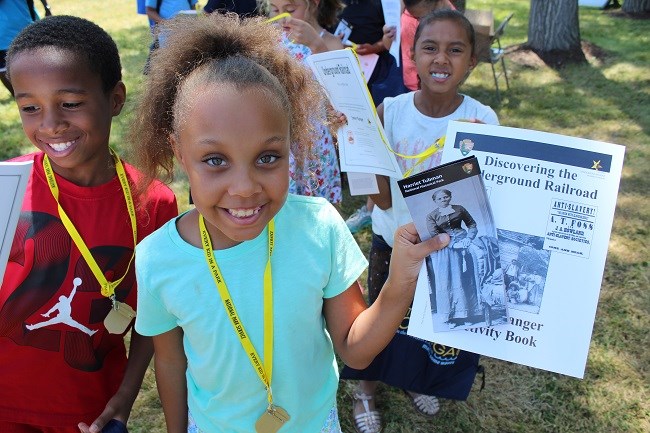 Kids holding up a Junior Ranger book