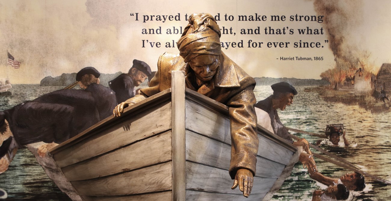 Statue of Harriet Tubman reaching out of a boat to help people in the water