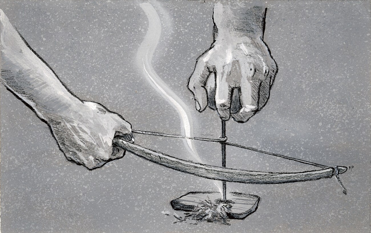 One hand holds a bow horizontally with its cord wrapped around a drill held upright over a small piece of wood with loose shavings.