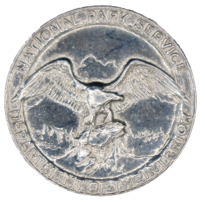 round silver badge with an eagle in the center