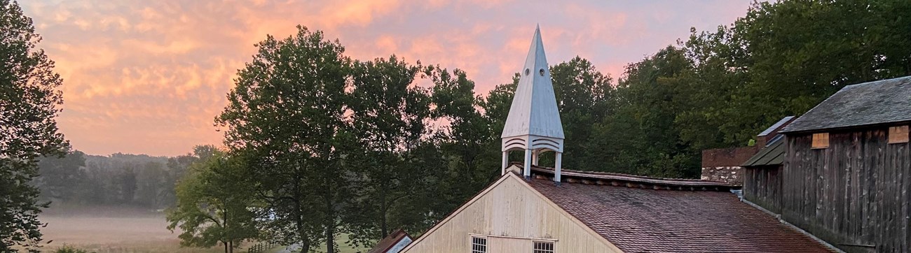 A large white building with wooden roof and white steeple at the top. A large white building with wooden roof and white steeple at the top.