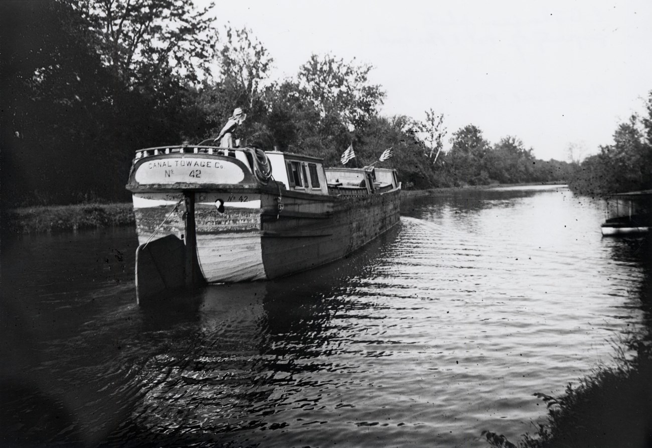 Woman at the tiller of a large canal boat