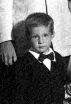 a young boy wearing a suit jacket and bow tie