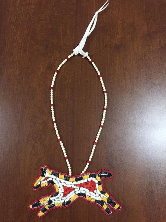 A beaded necklace with horse medallion.