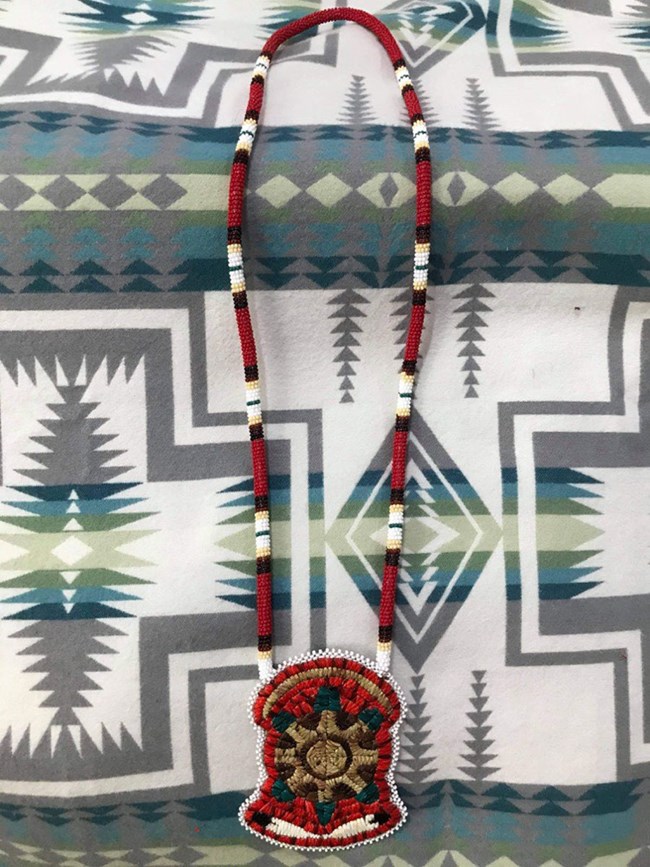 A beaded necklace with a turtle decoration.