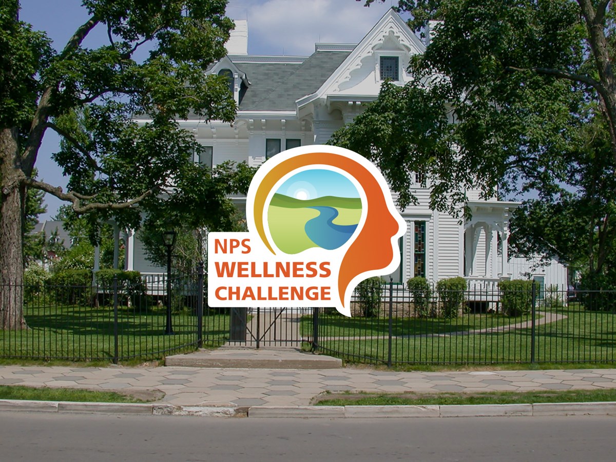Orange outline of head, wellness challenge logo, in front of Truman Home