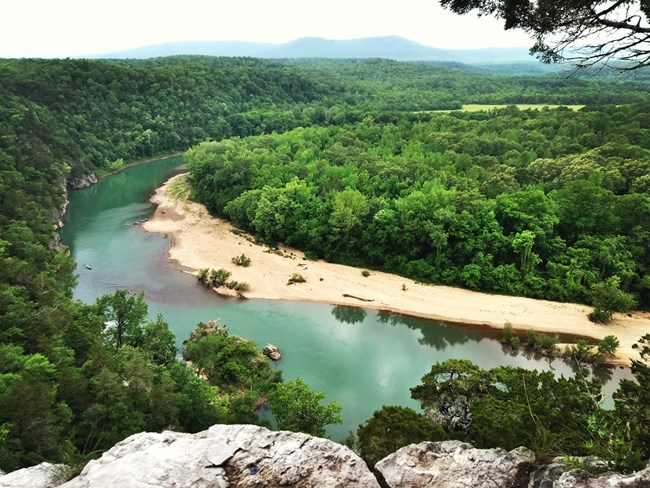 Overlooking a bend in the river from atop a stone cliff.