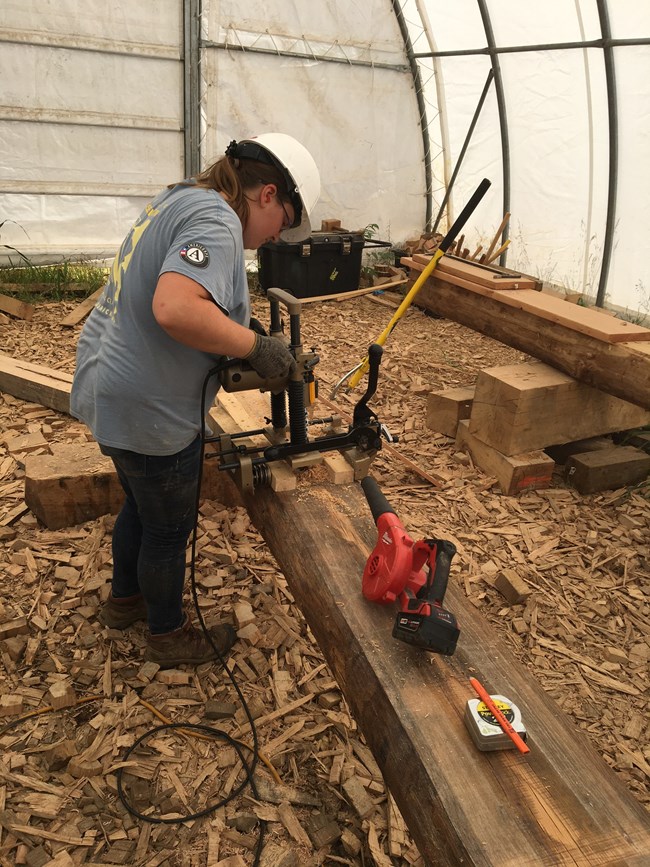 Helen preserving one of the many wooden pieces of a historic site.