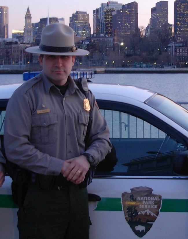 Henry with the city of Boston behind him. Park Ranger with the City of Boston behind him.