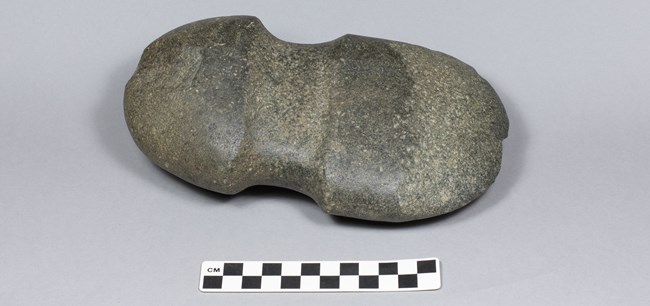 Gray oval stone with concave line around the middle.