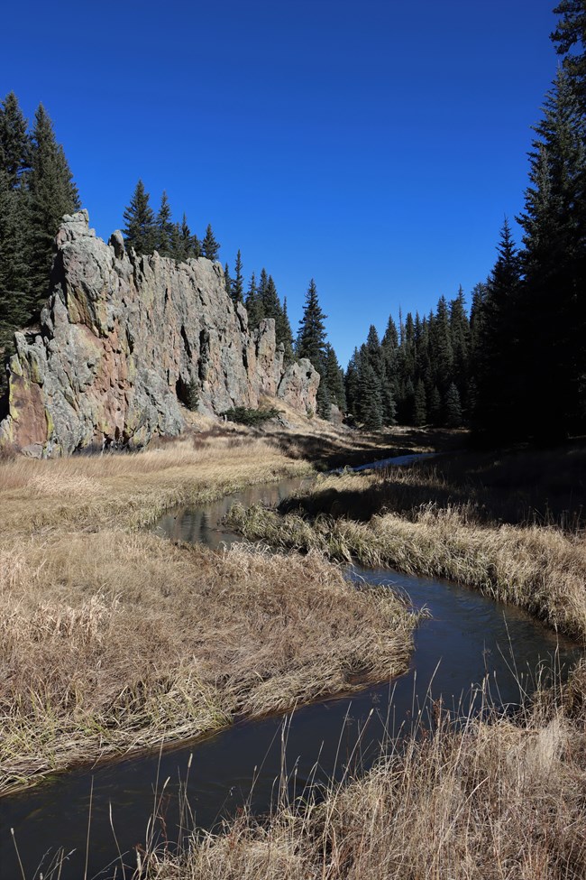 A stream meanders through a narrow valley.