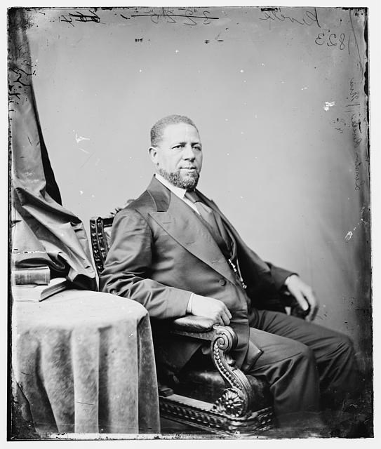 Hiram Revels, a Black man, sits side profile for his portrait