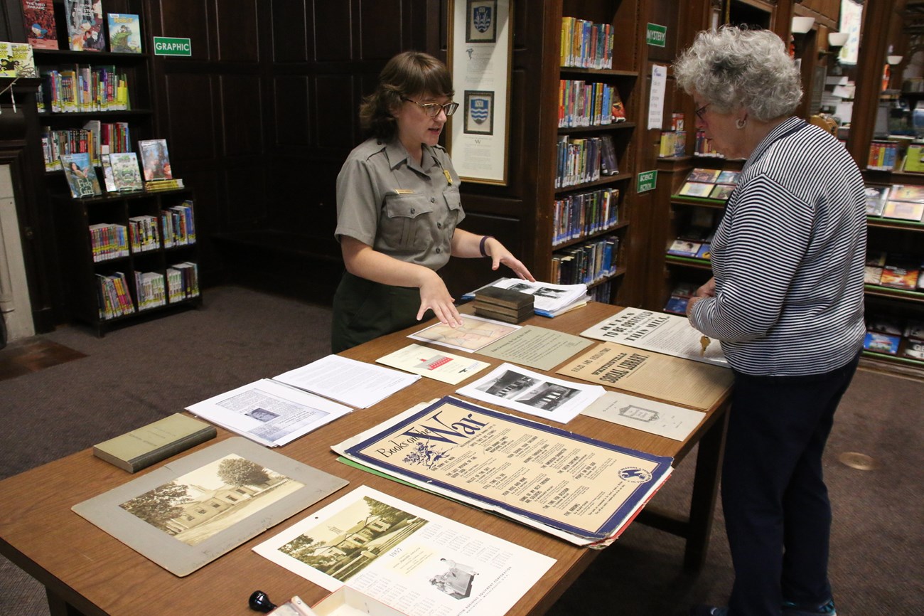 Park Ranger talking with visitor around table with information