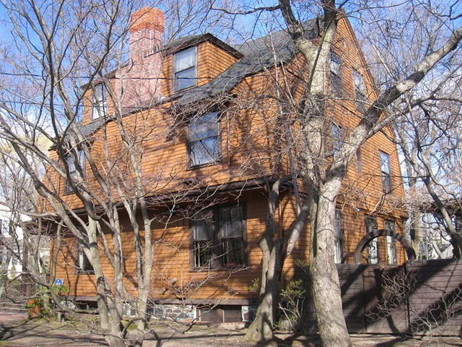 Exterior of a wooden-clad house with trees