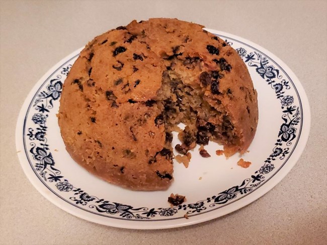 lt= Golden domed cake filled with dried fruit on plate