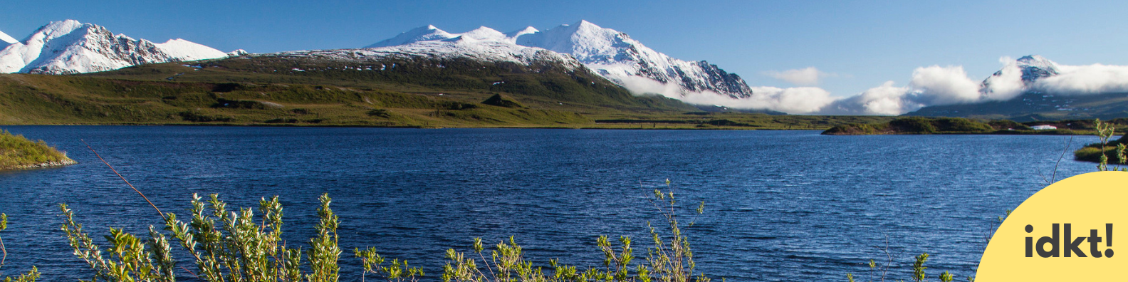 A body of water with a snow-capped mountain range behind it