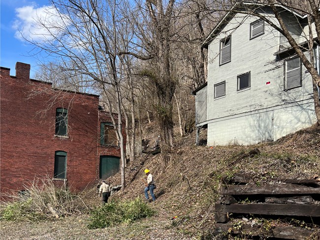 Fuel project work around historic structures. Workers examine a fuel reduction project around park historic structures