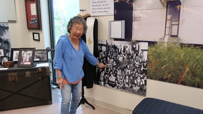 woman points to a young boy in a black and white photo of a school class