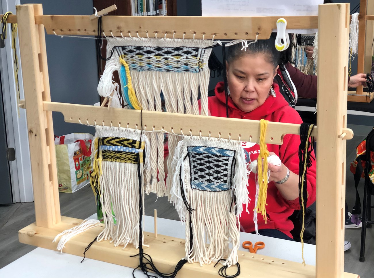 Weaving Strength in Women A weaver actively working on several Tlingit items