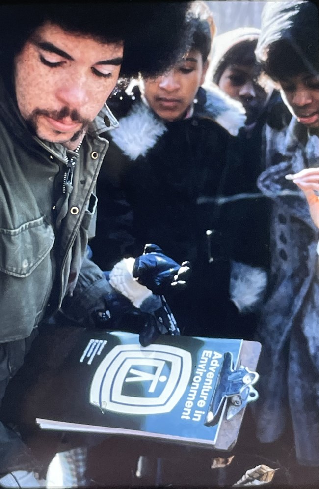 A man carries a clipboard with Adventure in Environment activity on it