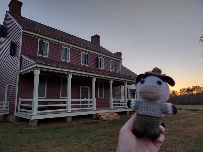 Ranger Cow is held in front of a home