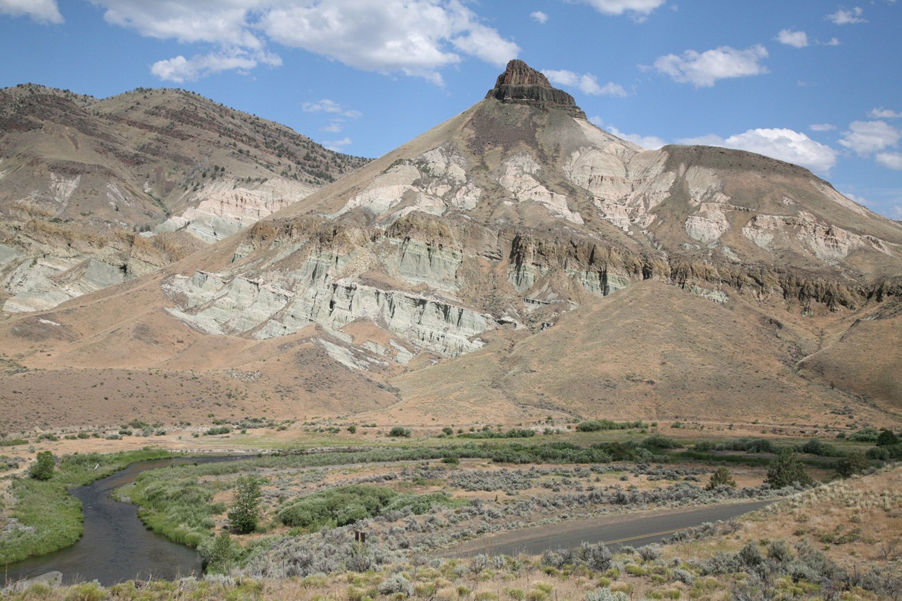 Photo of a tall peak with exposed rock layers.