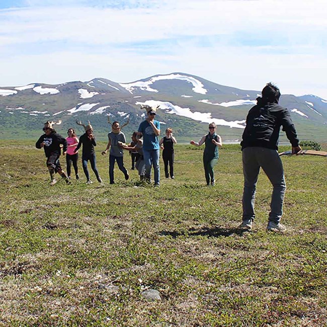 Youth act out traditional caribou hunting methods.