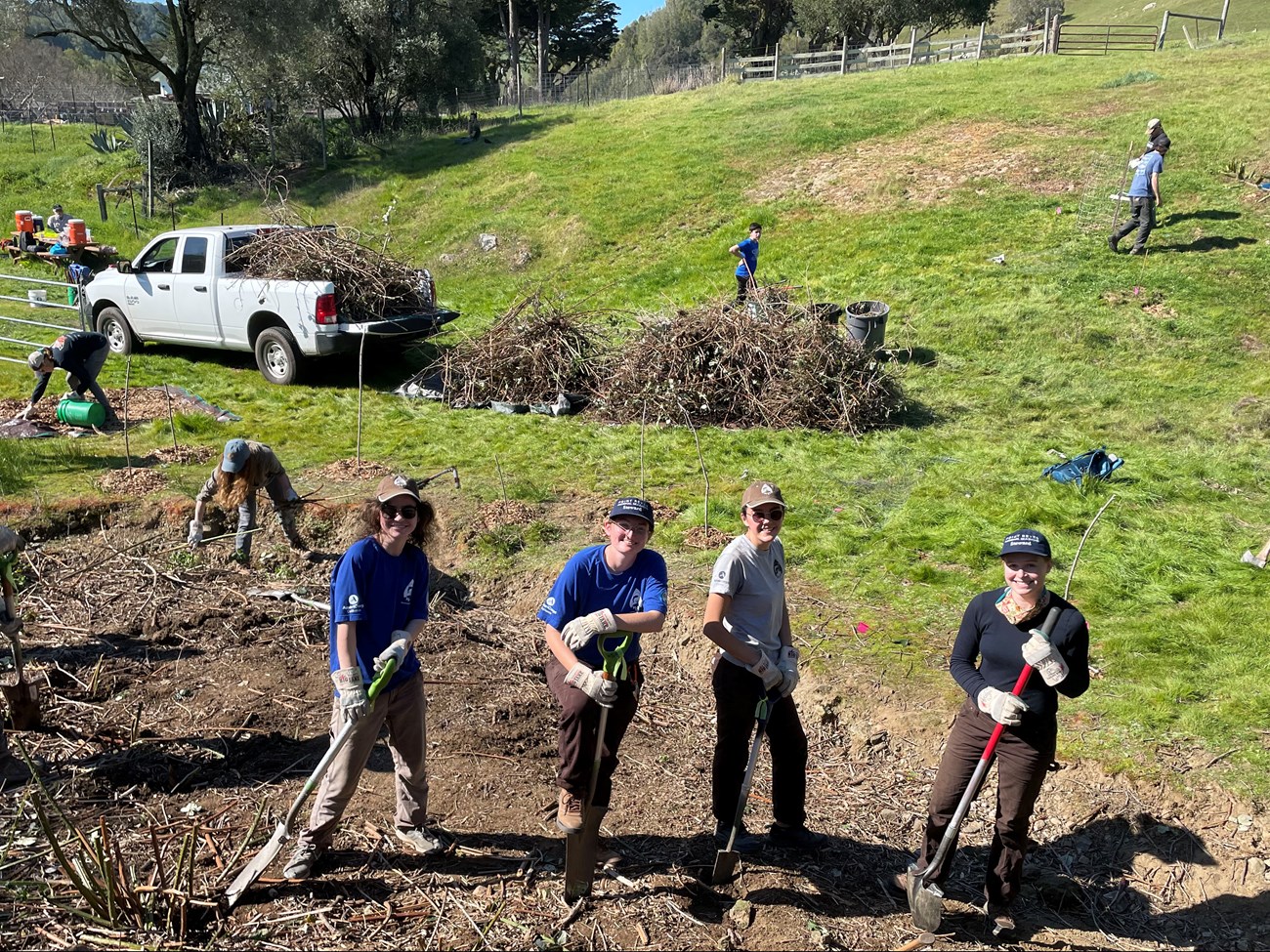 Watershed Awareness Volunteer Event Four people working side by side with shovels, as others work on different tasks in the background.