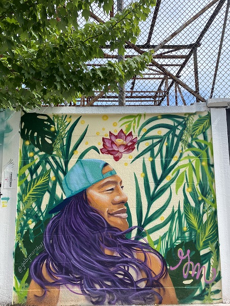 Building wall with colorful painting of a person with long hair