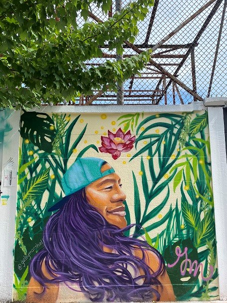 Building wall with colorful painting of a person with long hair