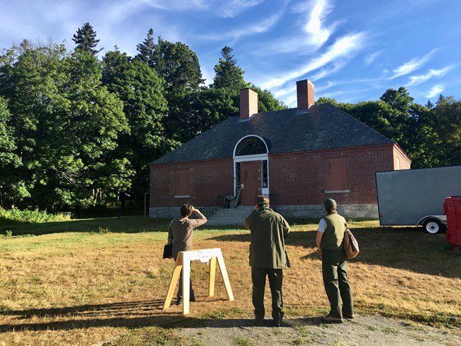 People standing in front of a brick historic structure