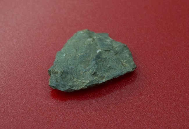 Piece of rhyolite flake on a red background.