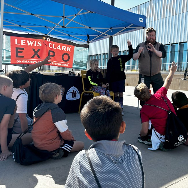 a man presenting tools in front of a group of children