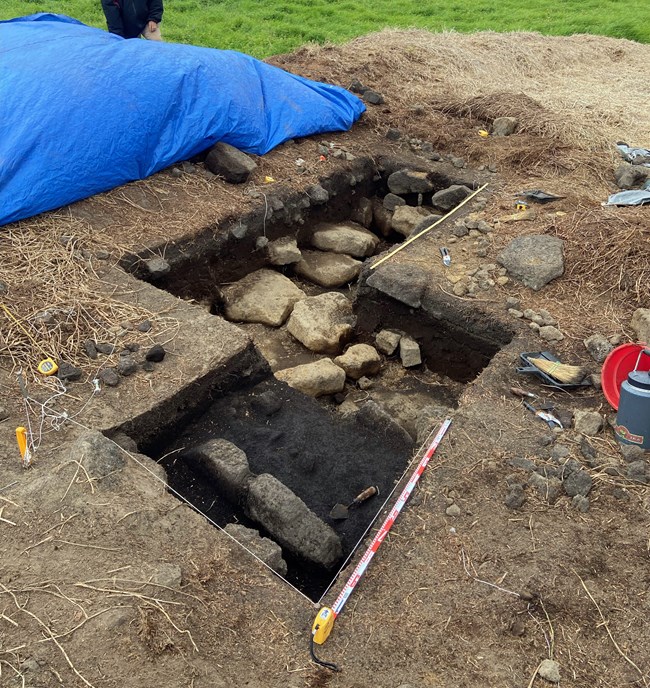 Two excavation pits showing stacked stones of kuaiwi