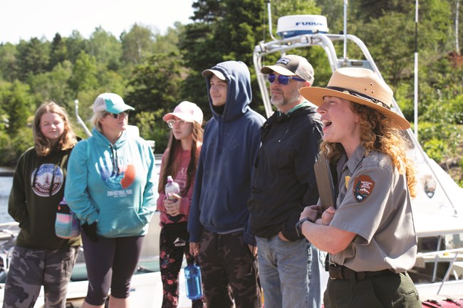 ISRO_Barse-Margaret_Ranger Behnke_Delivers-Orientation-5 A park ranger holding a clipboard smiles while she delivers a presentation to a crowd.