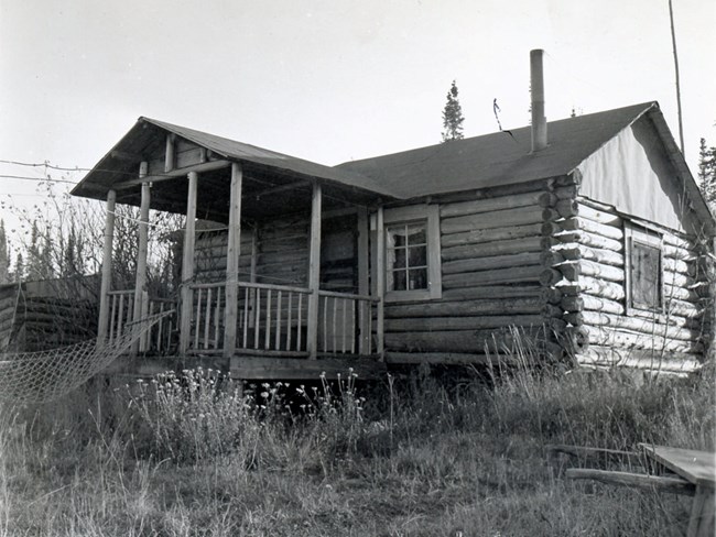 well constructed log cabin with square, covered front porch