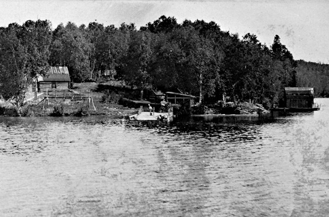 cabin looking out over McCargoe Cove, child on dock, fish house at right