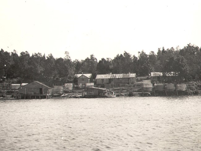 Mattson Fishery fishing cabins, many nets drying, boats at shore