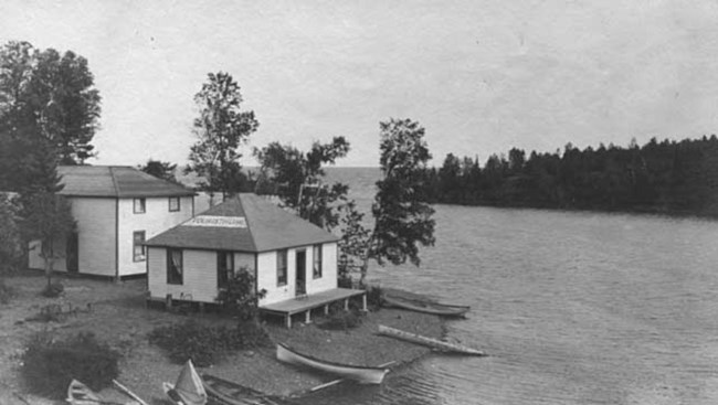 half dozen canoes pulled up in front of lodge