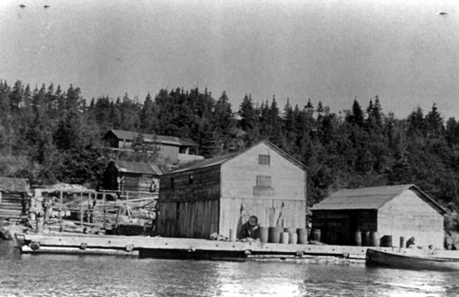 fish house with barrels and large dock out front