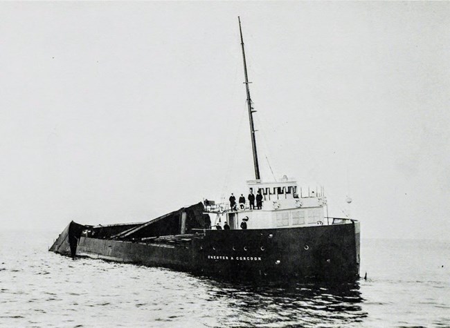 starboard view of the first few feet of the SS Chester A. Congdon, bottomed out on Canoe Rocks, with some of crew in and around wheelhouse