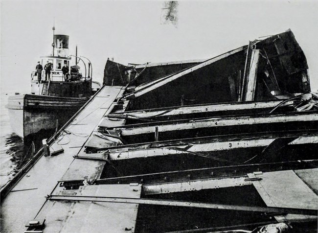 the mangled deck of the grounded CHESTER A. CONGDON, with people standing on the deck of the SARNIA alongside it