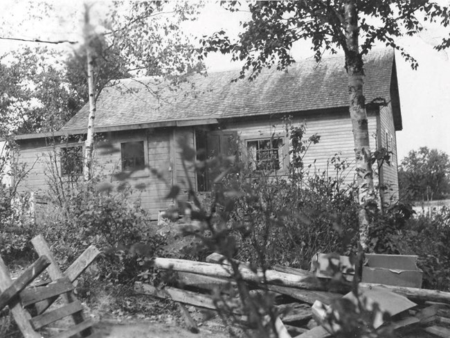 rectangular wood sided cabin with back door ajar