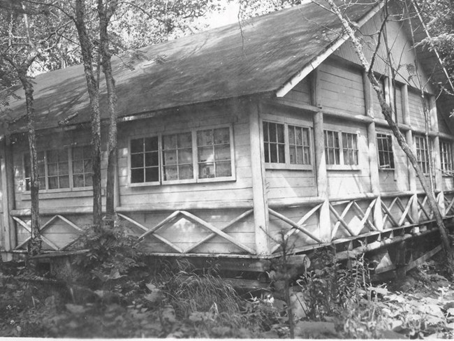 two story log cabin with wood hewn accents around the large building