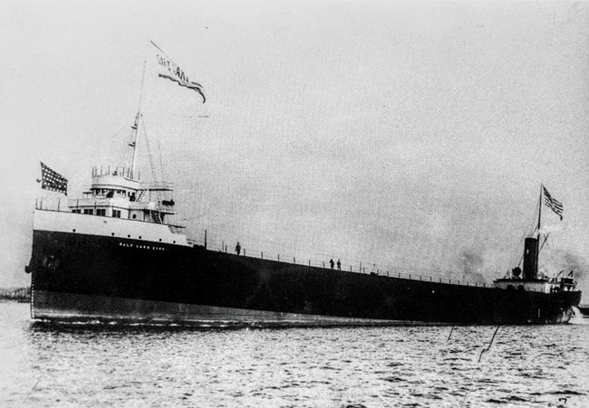 bow view of the SS SALT LAKE CITY with 'Salt Lake City' flag flying atop the wheelhouse