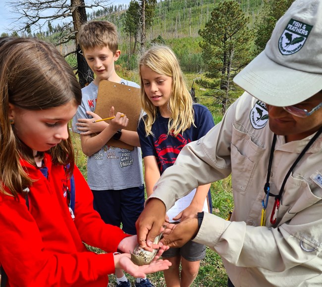 A student holding a bird that Erwin is banding